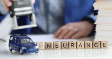 Agent stamps car insurance contract closeup