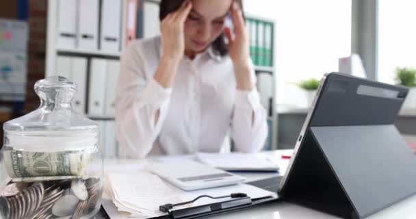 Upset businesswoman with headache at workplace — стоковое видео