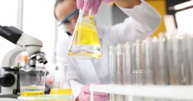 Scientist conducts chemical experiment in flask with oil
