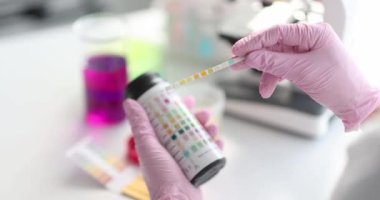 Scientist working with colored litmus paper in laboratory