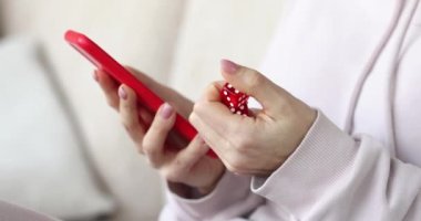 Smartphone and dice in female hand closeup