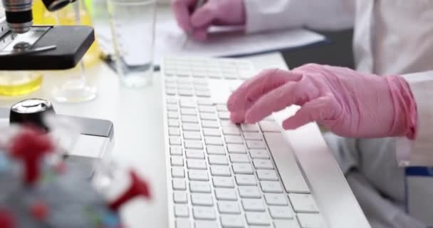 Doctor is typing on keyboard in laboratory closeup — Vídeos de Stock