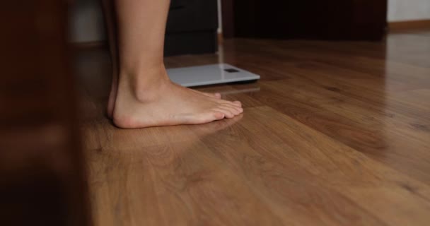 Woman putting in bed and weighing on floor scales closeup 4k movie — Stock video