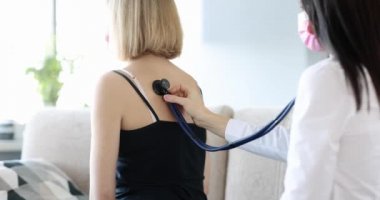 Doctor listens to patient lungs from back at home