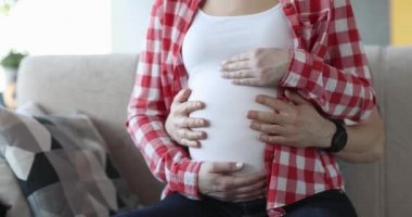 Man and woman are stroking belly in last month of pregnancy