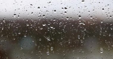 Raindrops on glass on gray background. Rainy season autumn loneliness and depression