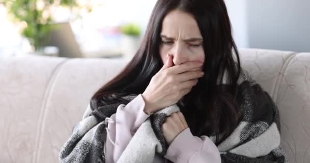 Sick woman with strong cough and thermometer in blanket on couch — Vídeo de Stock