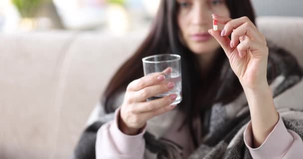 Mulher está segurando comprimido médico e vidro de água — Vídeo de Stock