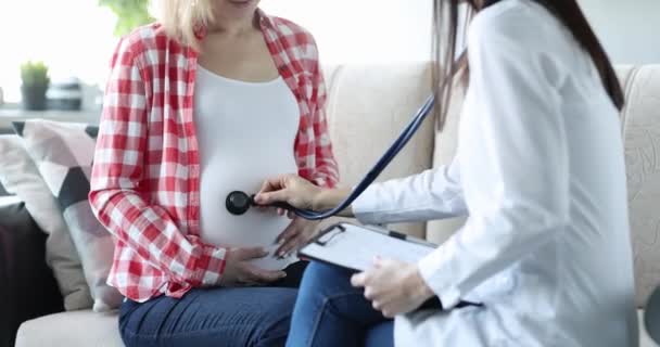 डॉक्टर स्टेथोस्कोपसह गर्भवती महिलेचे पोट ऐकतो — स्टॉक व्हिडिओ