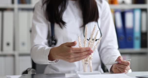 Doctor shows model of hand and bones of skeleton — Stockvideo