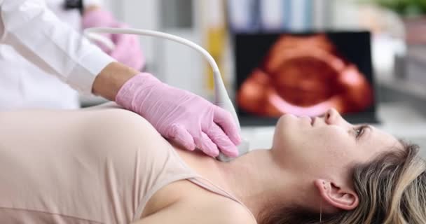 Ο γιατρός εξετάζει το λαιμό της γυναίκας ασθενή με υπερηχογράφημα κατά τη διάρκεια της ιατρικής εξέτασης στο σύγχρονο νοσοκομείο — Αρχείο Βίντεο