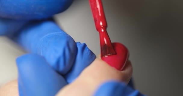 Manicurist paints client nails with bright red polish — Stok video