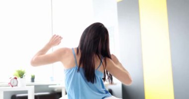 Genç bir kadın uyanıyor ve ellerini geriye doğru çekiyor. 4K film yavaş çekim.