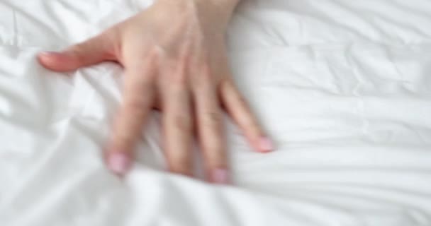 Vrouw hand knijpen wit bed tijdens passionele orgasme closeup 4k film slow motion — Stockvideo