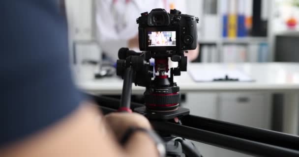 Videographer filming doctor on professional camera closeup 4k movie slow motion — Video