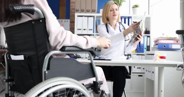 Médico examinando radiografía de paciente discapacitado en silla de ruedas 4k película cámara lenta — Vídeos de Stock