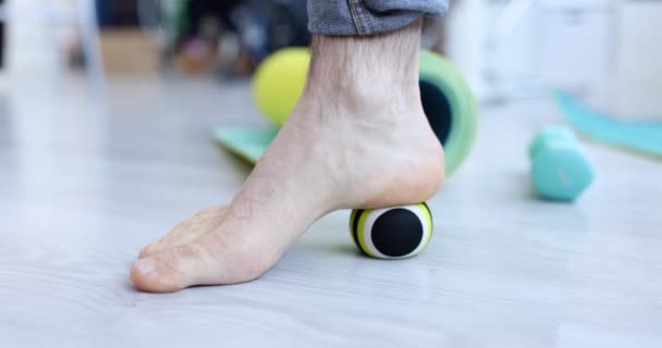 Man massaging his leg with ball on floor closeup 4k movie slow motion — стоковое видео