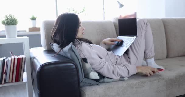 Woman working remotely at home and receiving unpleasant message on her phone 4k movie — ストック動画