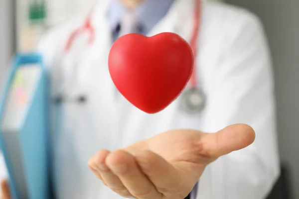 Cardiologul aruncă inima roșie din plastic și o prinde în palmă, salvează viața prin donație sau activitate caritabilă — Fotografie, imagine de stoc