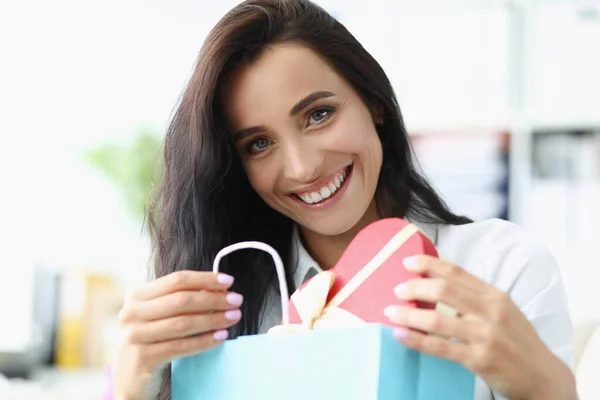 Morena mujer feliz de abrir caja festiva con presente, mirada curiosa y alegre — Foto de Stock