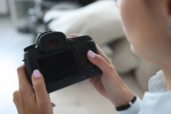 Woman photographer go through pics on camera backstage after photoshot