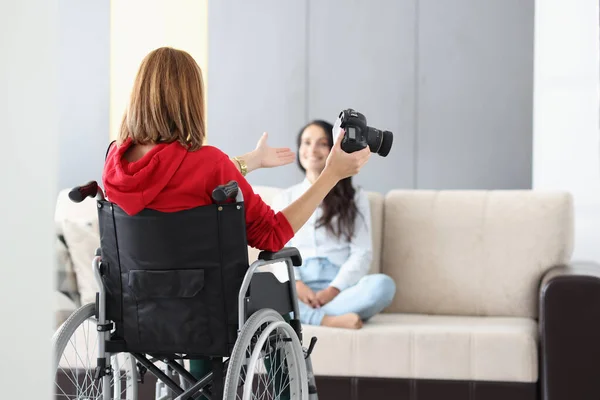Професійний фотограф у інвалідному візку дає поради щодо позування на моделі на дивані — стокове фото