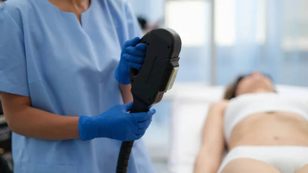 Beautician holding hybrid laser hair removal machine in beauty salon closeup — ストック写真