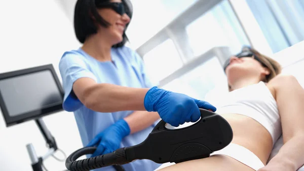 Beautician doing laser hair removal bikini area clients in beauty salon closeup — Zdjęcie stockowe
