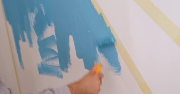 Mestre pintura parede branca com tinta azul usando rolo closeup filme 4k — Vídeo de Stock
