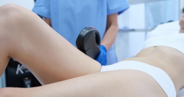 Doctor doing laser hair removal of legs of female client closeup 4k movie — Stockvideo