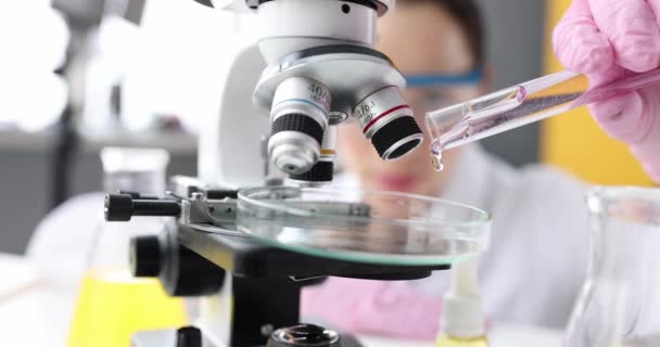 Kvinna laboratorieassistent lägger klar flytande gel till petriskål — Stockvideo