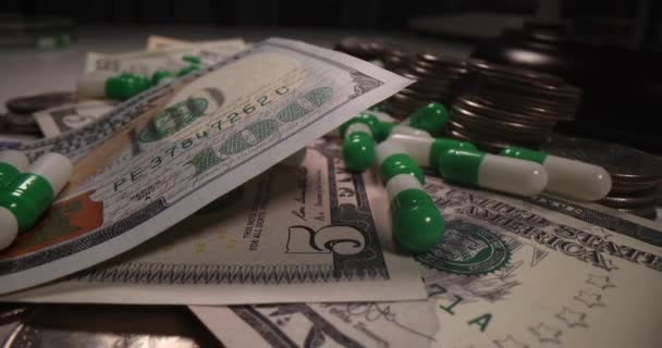 Medical pills with dollars and coins on dark background — Stockvideo