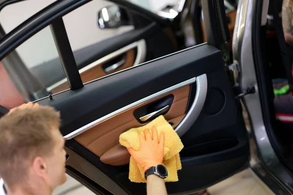 Man cleans car door handle with cloth and car detailing — Stock Photo, Image