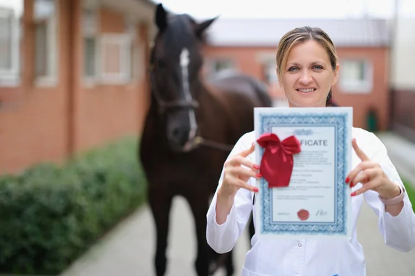 Veterinarian holds medical certificate for thoroughbred horse