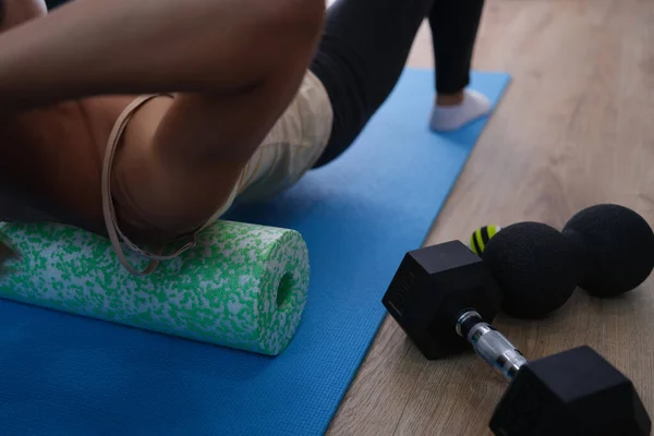 Woman does exercises lying on roller and balancing