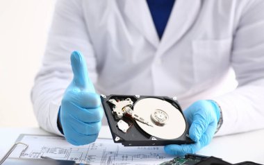 Üniformalı adam bilgisayardan, bilgisayardan ve okuyucudan sökülmüş sabit diski tut.
