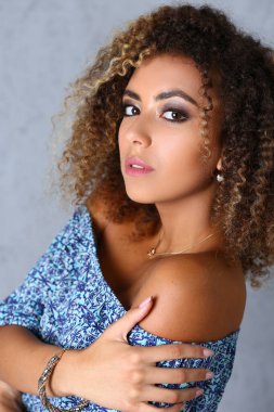 Profesyonel stüdyoda poz veren kıvırcık saçlı göz kamaştırıcı Latin kadın. Latin Amerikalı kadın model ajansı için çalışıyor.