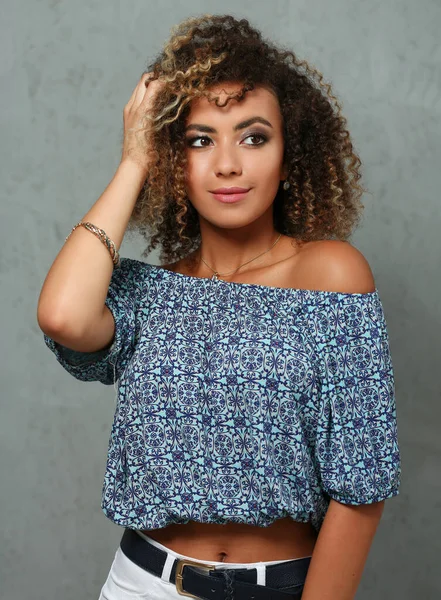 Egzotik görünümlü, kıvırcık saçlı güzel bir bayan.