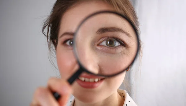 Young woman look through magnifying loupe, interested in everything — Stockfoto