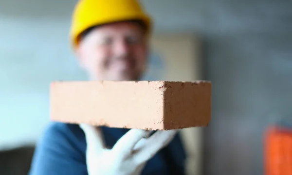 Handyman hold red brick on hand, worker in protective gloves, building object, repair and fix — Stock Photo, Image