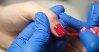 Master painting nails with red varnish in beauty salon closeup 4k movie