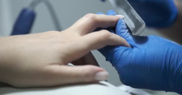 Maestro haciendo manicura con uñas lima primer plano película 4k — Vídeo de stock