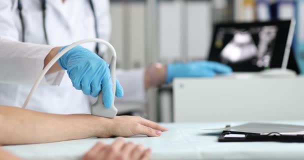 Врач-травматолог делает ультразвук руки пациента в клинике крупным планом 4К фильм — стоковое видео