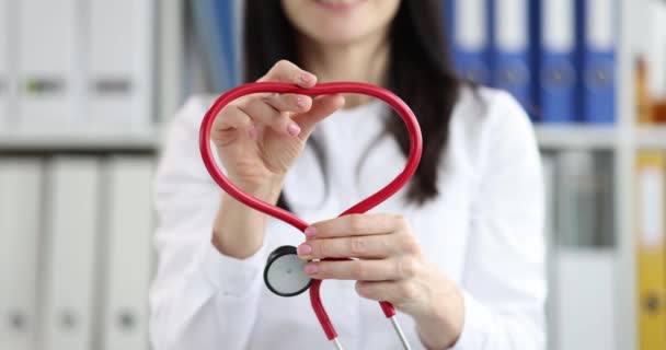 Doctor cardiologist making heart from red stethoscope closeup 4k movie slow motion — Vídeo de Stock