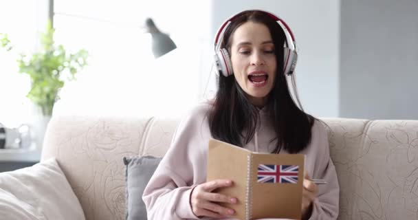 Woman in headphones learning english at home 4k movie — Αρχείο Βίντεο
