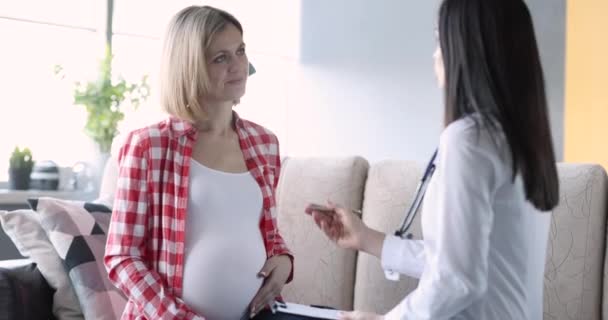 Doctor obstetrician gynecologist communicating with pregnant patient at home 4k movie — Stok video