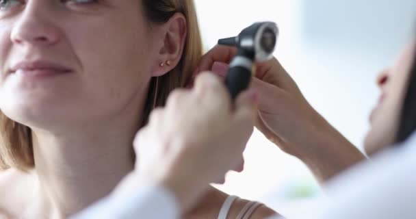 Doctor otorhinolaryngologist looking at membrane of ear of patient with help of otoscope 4k movie slow motion — Vídeos de Stock