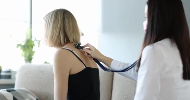 Doctor listening to flu sick woman with stethoscope at home 4k movie — Αρχείο Βίντεο