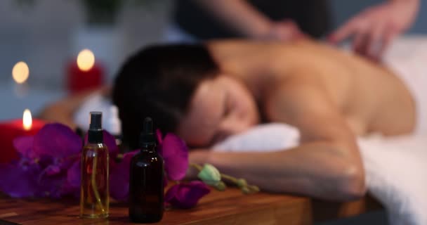 Cosmetic aroma oils standing near client and massage therapist in spa closeup 4k movie — Vídeo de Stock