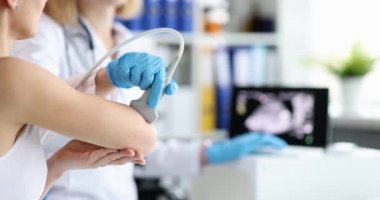 Traumatologist conducting ultrasound examination of patient elbow joint closeup 4k movie slow motion